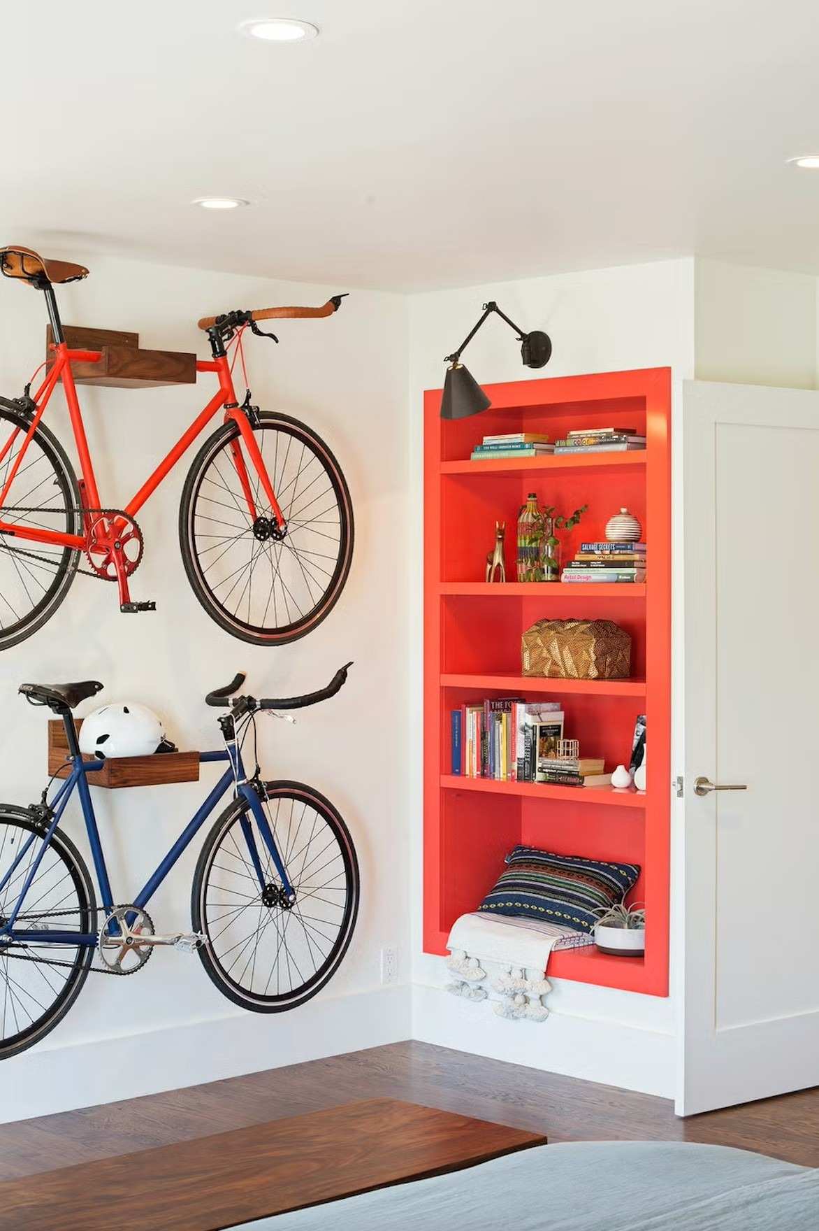 A separate source storage arrangement raises bicycles onto a wall beside open shelving, leaving a clearer area below.