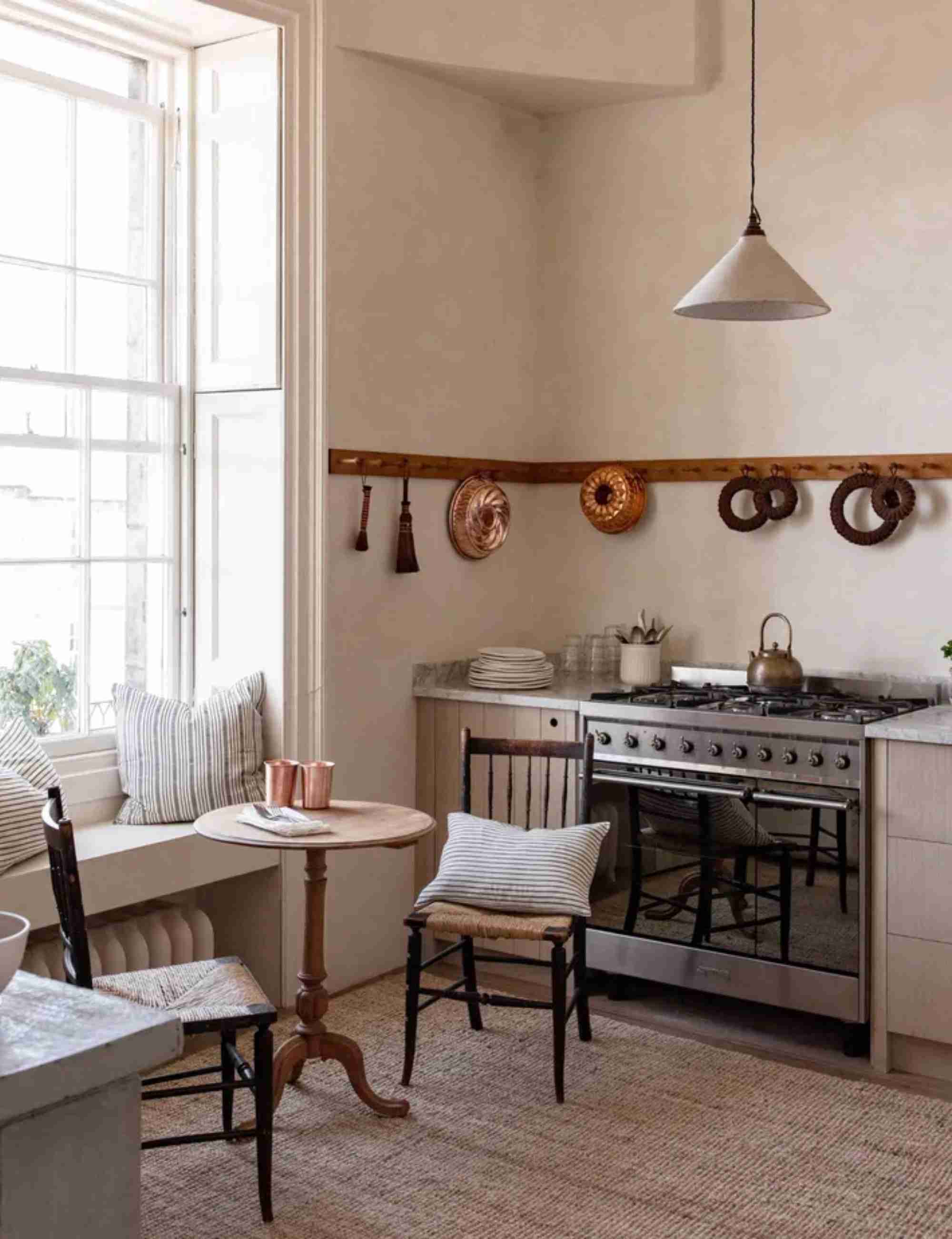 The reference kitchen displays selected copper pieces on wall hooks, illustrating vertical storage rather than another floor-standing cabinet.