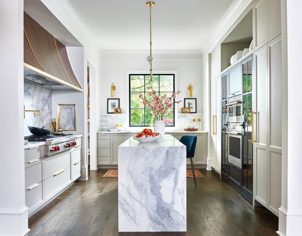 A source kitchen uses pale cabinetry and a central stone-patterned island, illustrating one room's distinct materials.