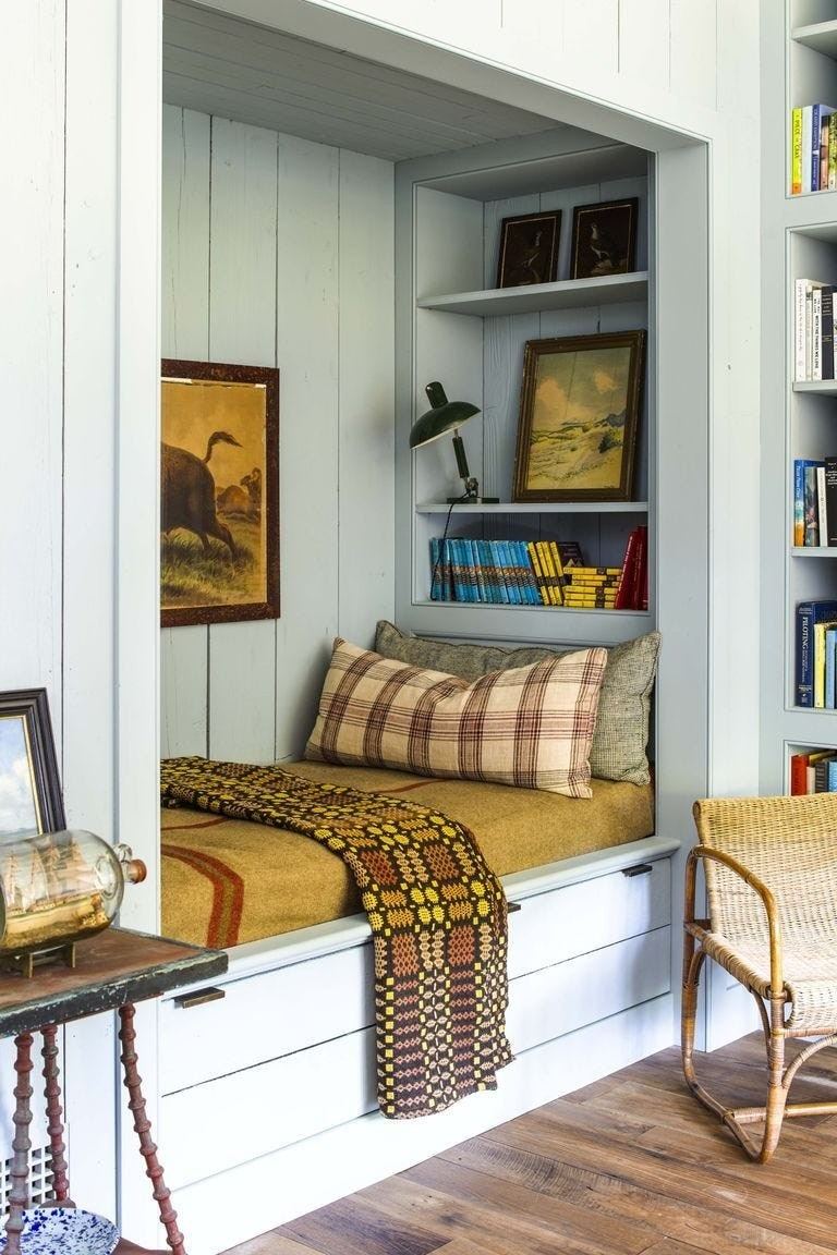The source daybed nook incorporates drawers below the cushioned seat and shelving beside it.