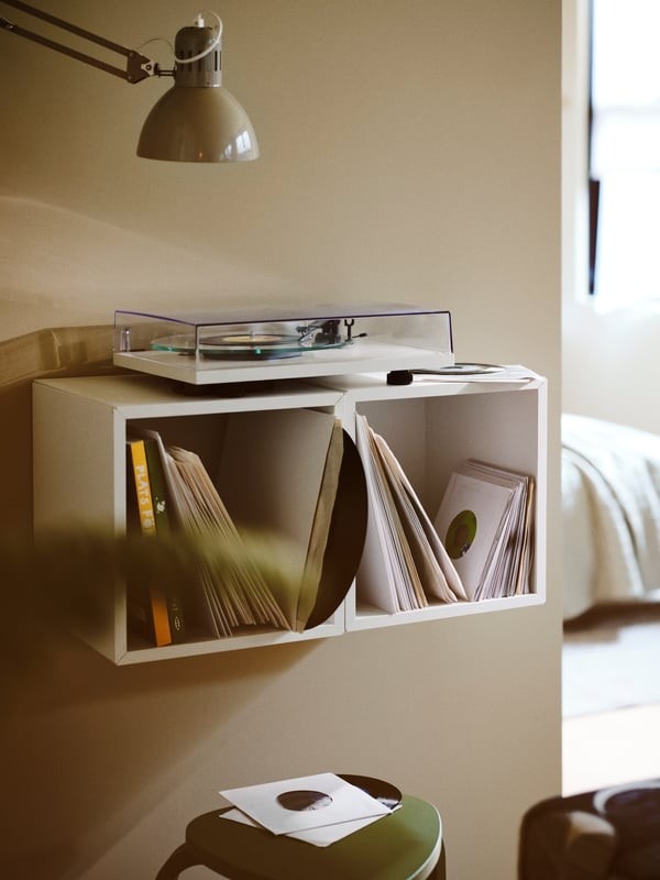 The apartment reference places records in wall-mounted storage with the turntable above, assigning those objects a location near the living area.