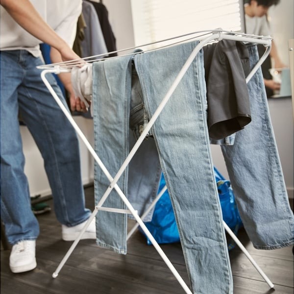 The first-apartment example includes a deployed folding drying rack, showing the space used during laundry rather than only its folded outline.