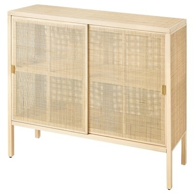 A light rattan cabinet from the source's featured range illustrates the quieter natural-material direction.
