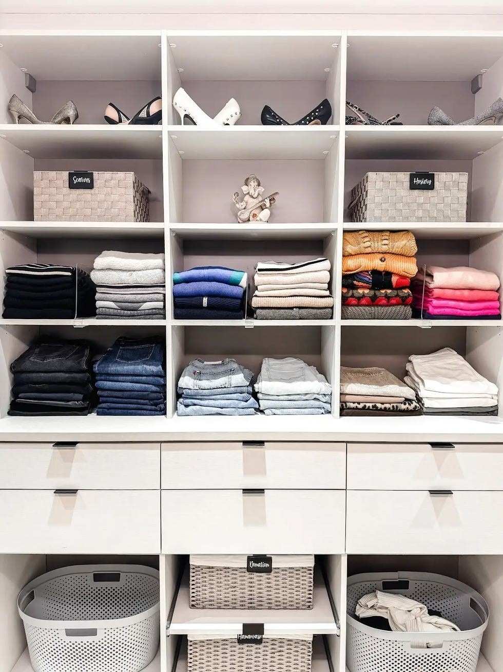 A source closet example groups folded clothing and shoes on shelves with baskets for distinct categories.