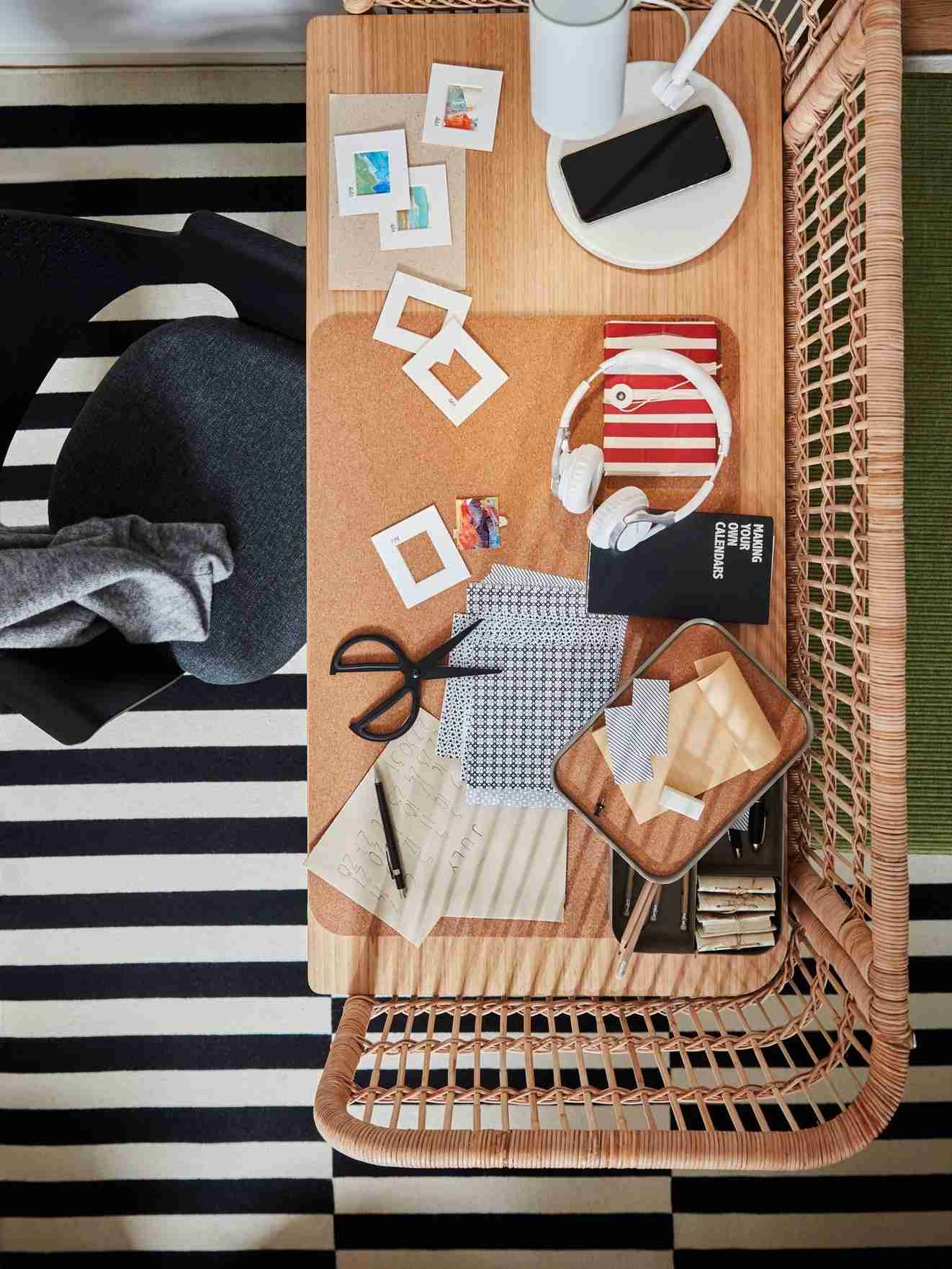 An overhead source view shows the rattan desk's working surface with a lamp, protective pad, boxes, and current materials.
