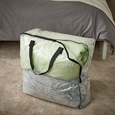 The source illustrates soft-sided storage bags beside a bed, offering a lower storage form distinct from the cover's upright cart.