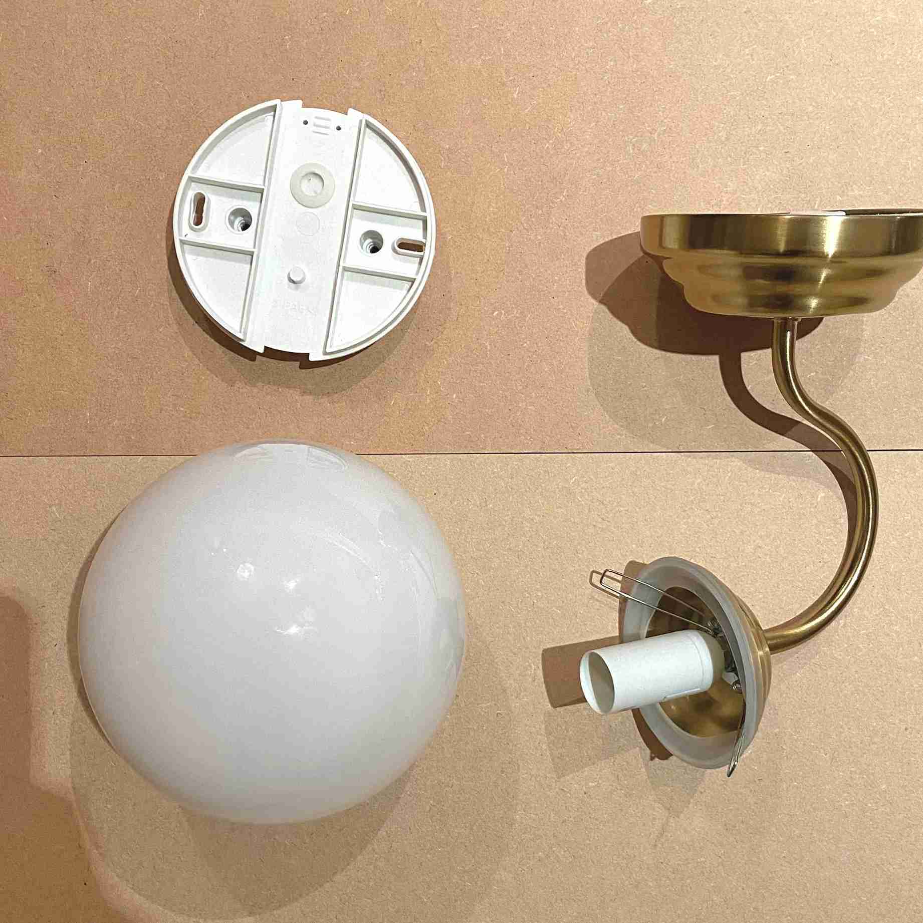 The source photograph lays out the disassembled decorative sconce components; it documents the individual experiment rather than a verified installation specification.
