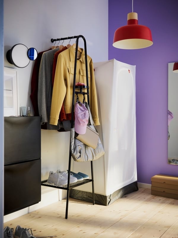 IKEA first-apartment example showing a clothes rack beside a lightweight fabric wardrobe.