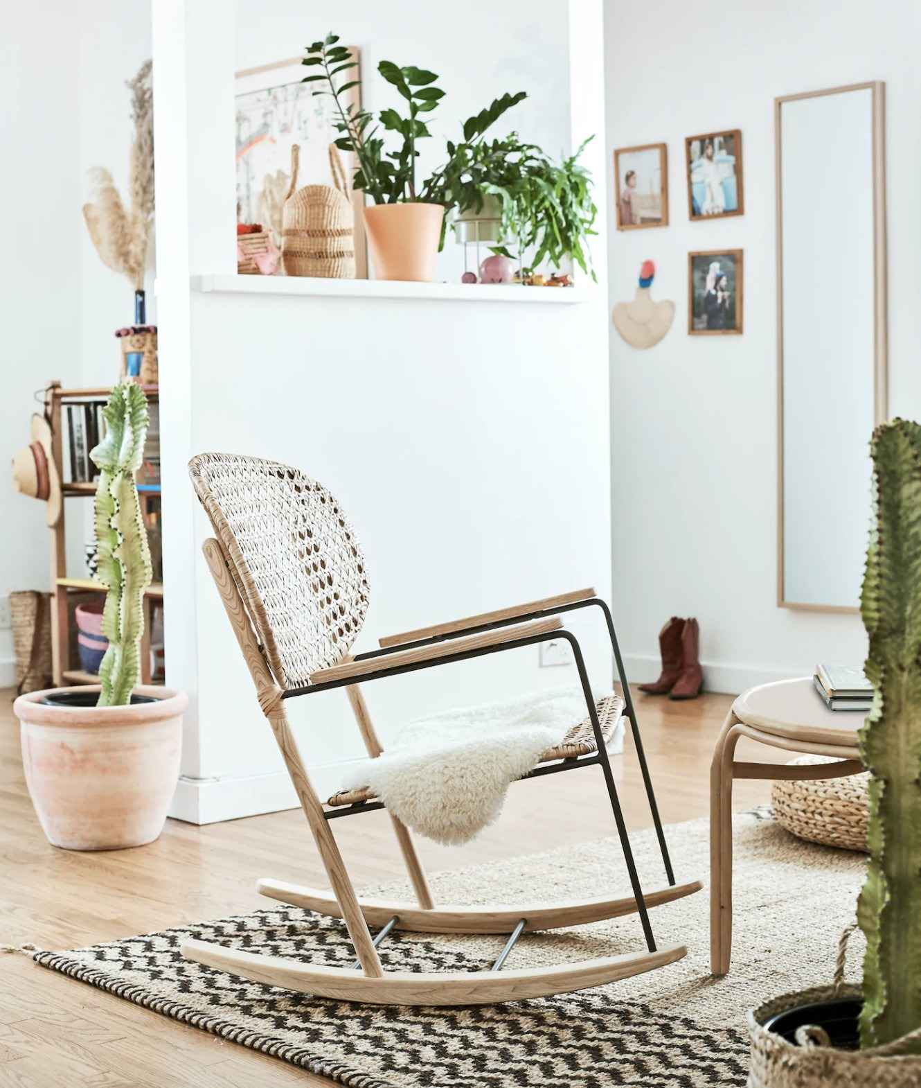 A separate source seating corner uses an open-framed rocking chair beside a rug and plants.