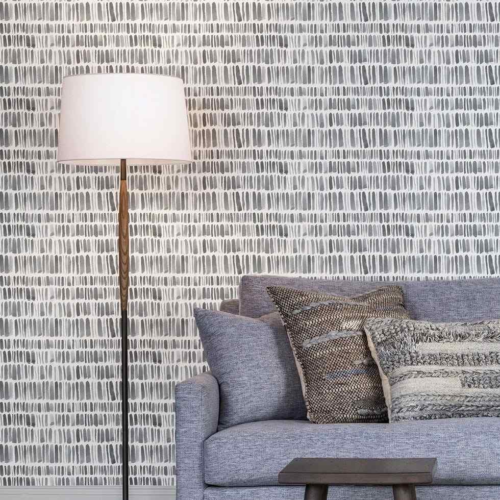 A separate source presentation uses a repeated painterly stripe behind a chair and floor lamp, illustrating a different pattern scale.