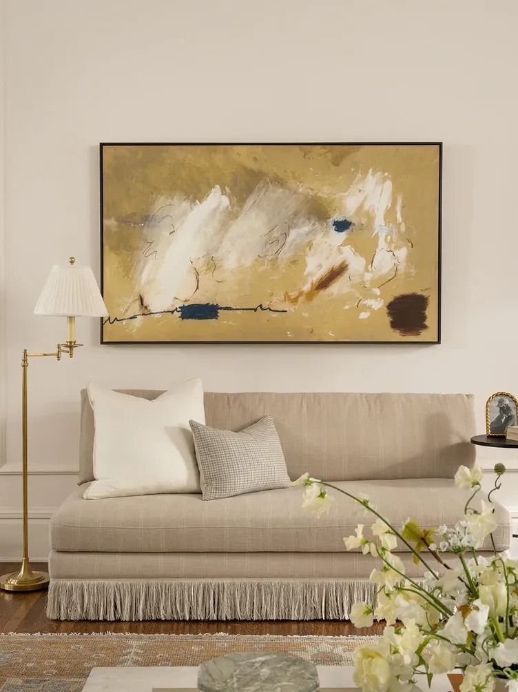 An armless fringed settee in the source illustrates a compact outline with traditional detailing.