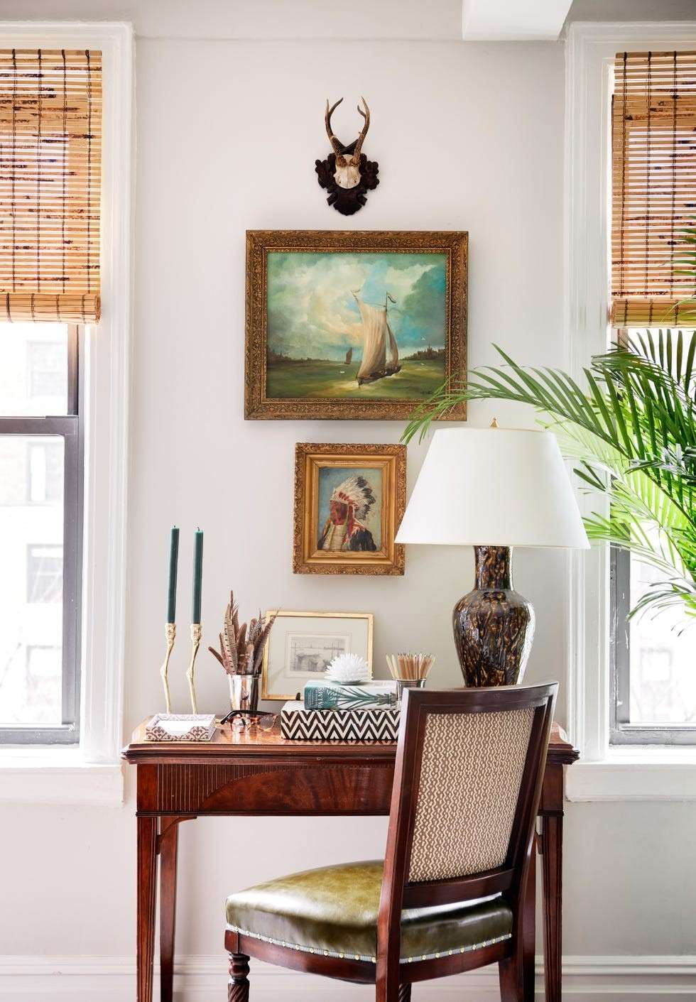 The source home tour shows the antique folding table serving as a work desk beneath framed artwork.