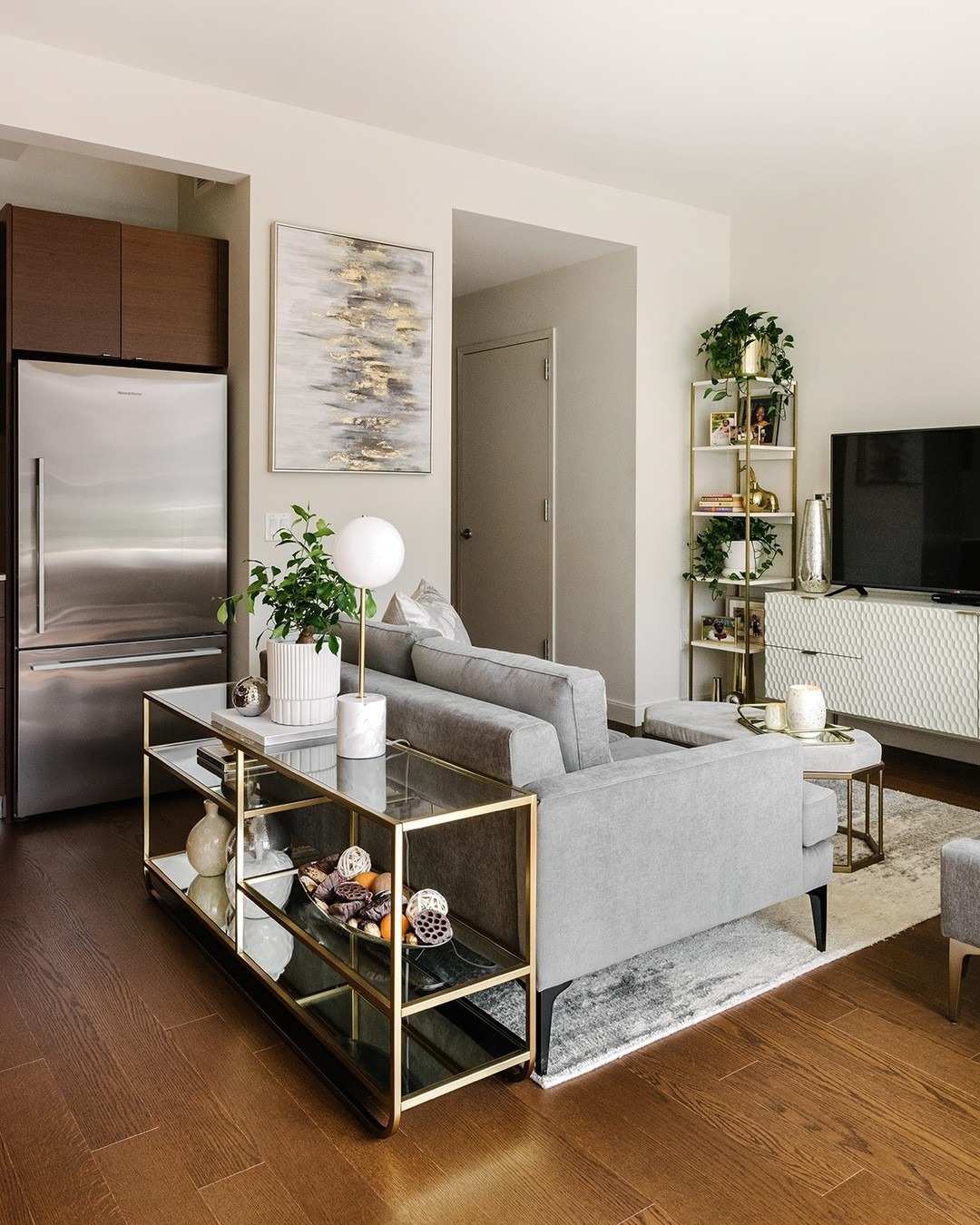 A separate source room uses the back of a gray sofa to mark the living area without a full-height partition.