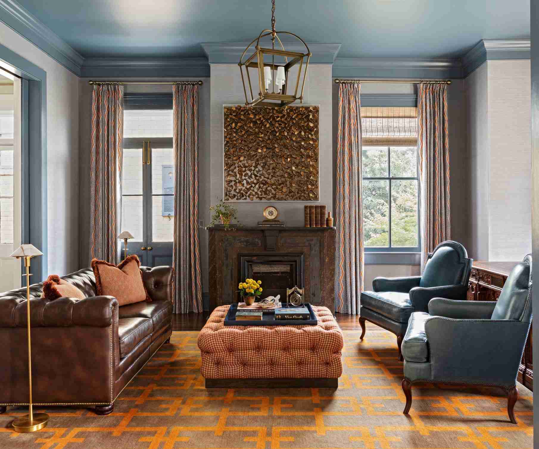 The reference room organizes opposing seats and a central ottoman around a fireplace.