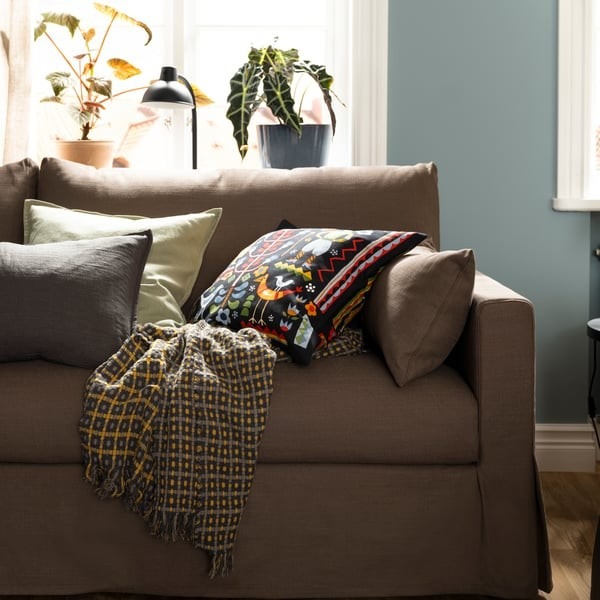 IKEA sofa arrangement combining a multicolored patterned cushion with quieter textiles.