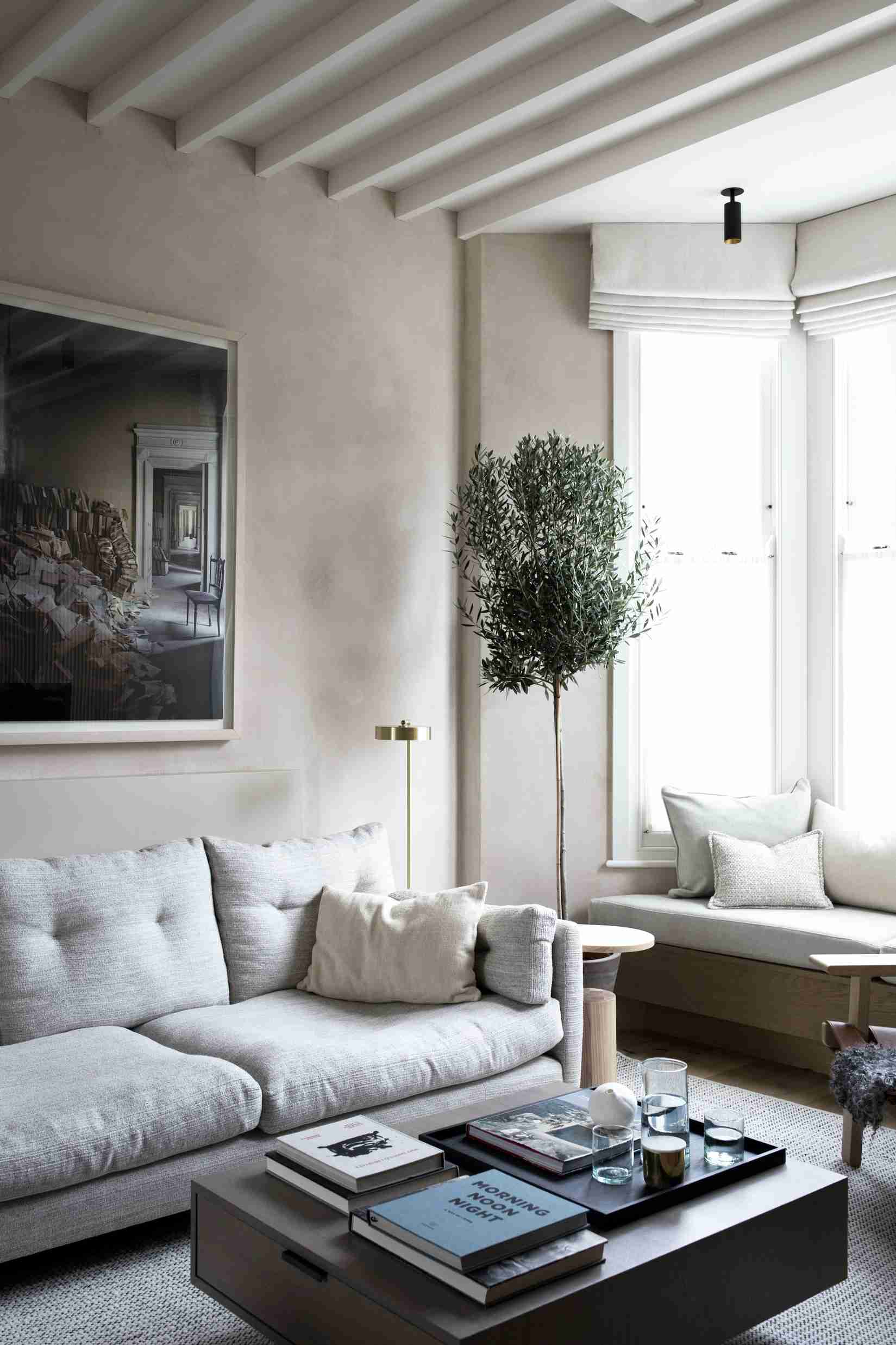 A separate source example uses a window seat beside the main sofa and a compact central table.