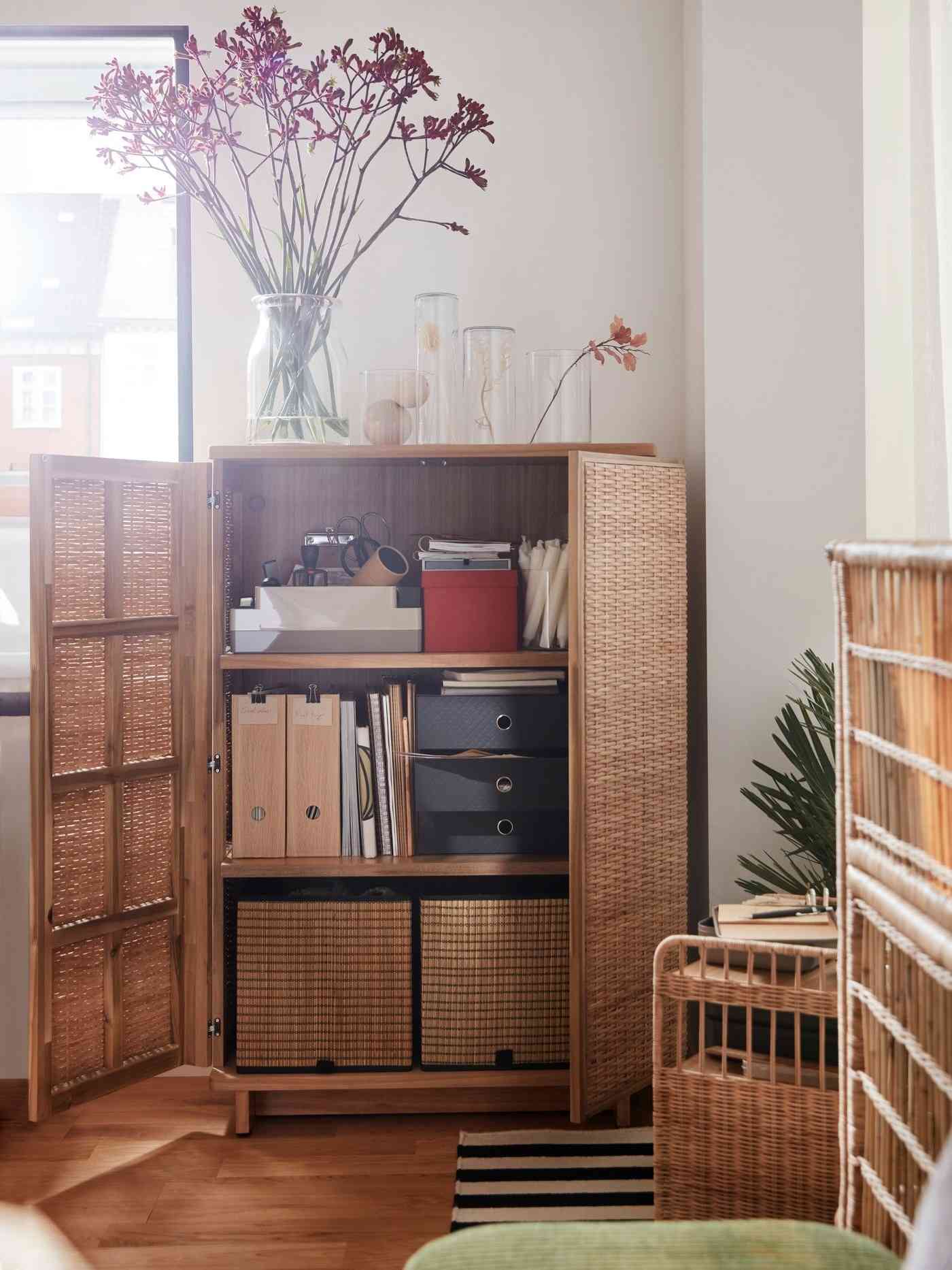 The source rattan cabinet is pictured with its doors open, revealing files, boxes, and smaller desk accessories.