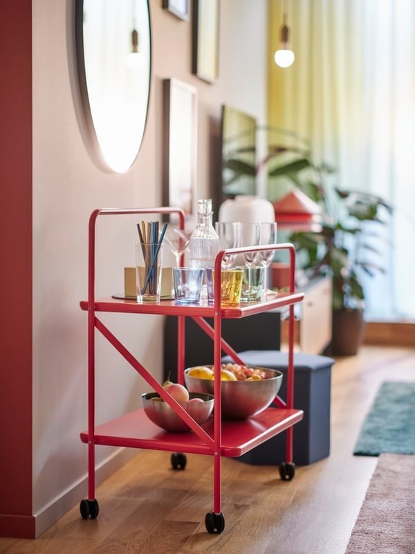 A red wheeled side table in the source provides a movable serving surface.