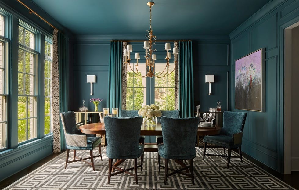 A separate dining room in the source uses deep blue-green walls and a central chandelier, illustrating the different atmosphere of an enclosed setting.