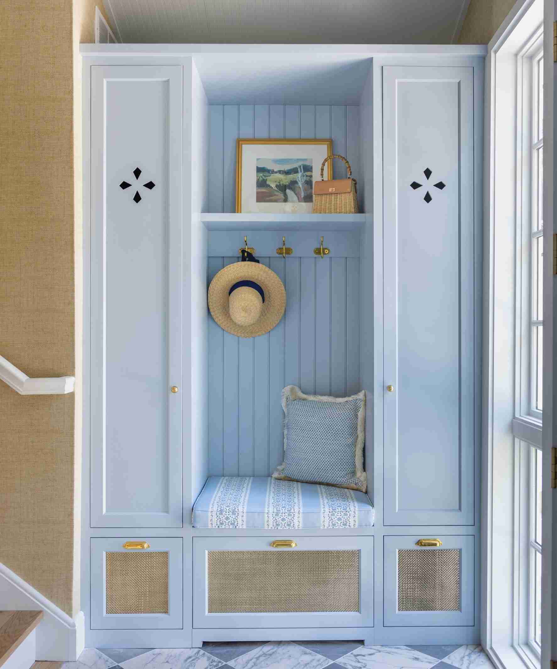 A separate source entrance uses pale blue fitted storage with a central seat and reachable hooks.