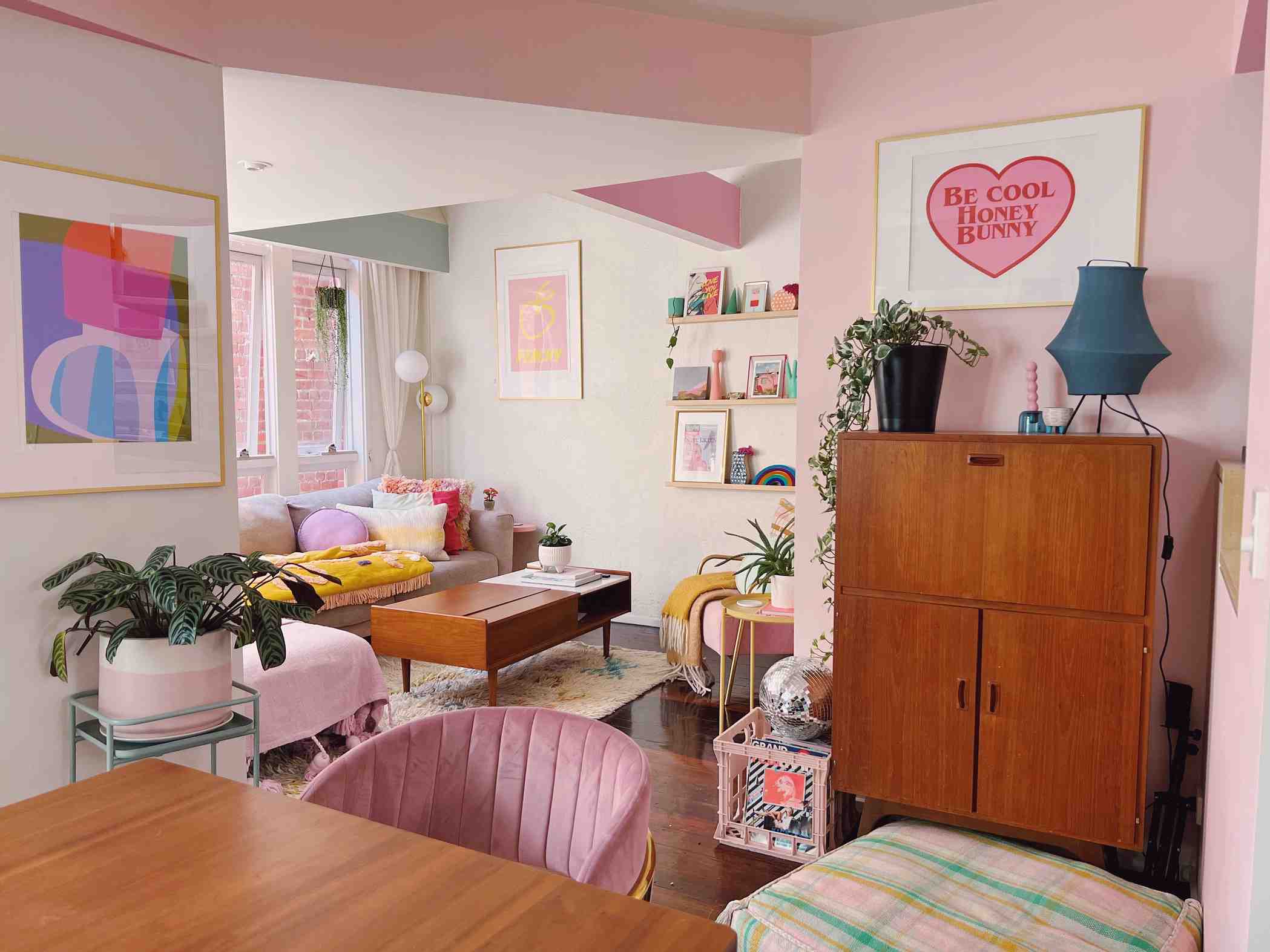 A wider source view shows the pink living area in relation to the dining furniture and taller storage, rather than repeating the cover framing.