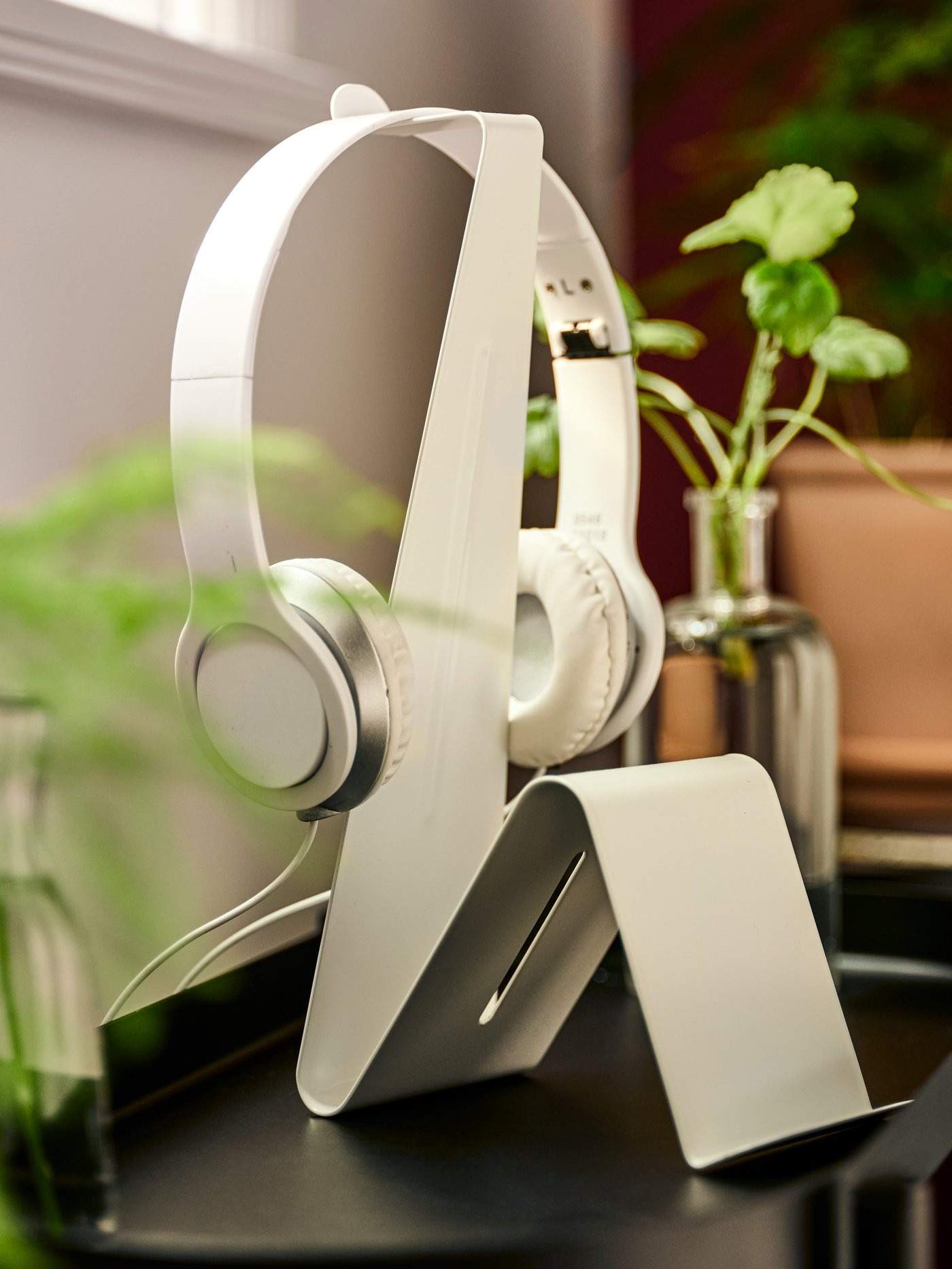 The source tablet and headset stand keeps a device and headphones together beside the individual seating area.