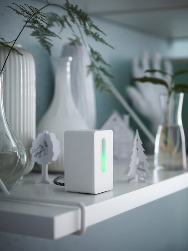The source air-quality sensor is pictured among vases and small decorative objects; its measured parameters depend on the actual product specification.